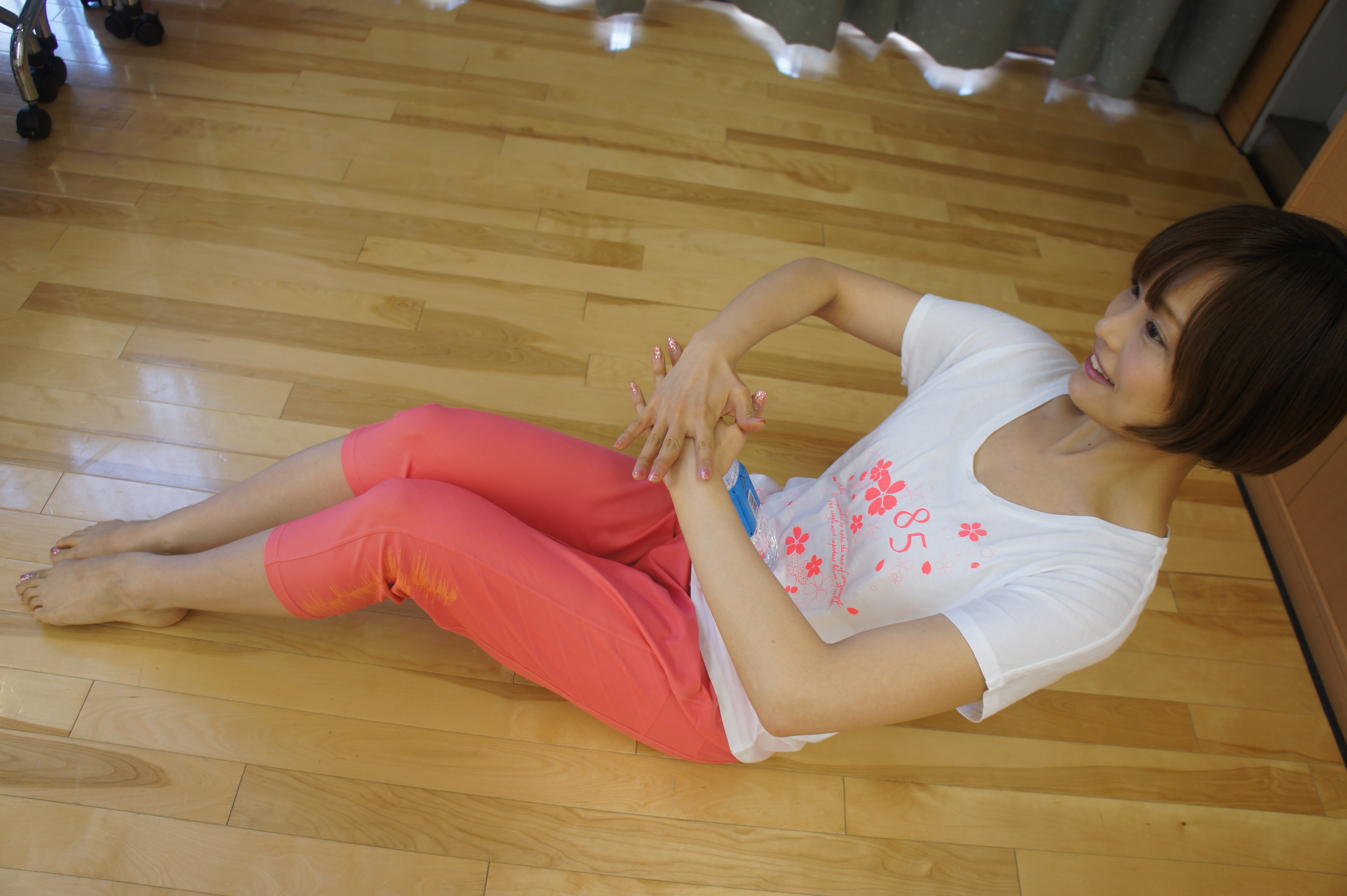 床に座り、膝を立てた状態でペットボトルをお腹にあて、上半身を後ろに倒す