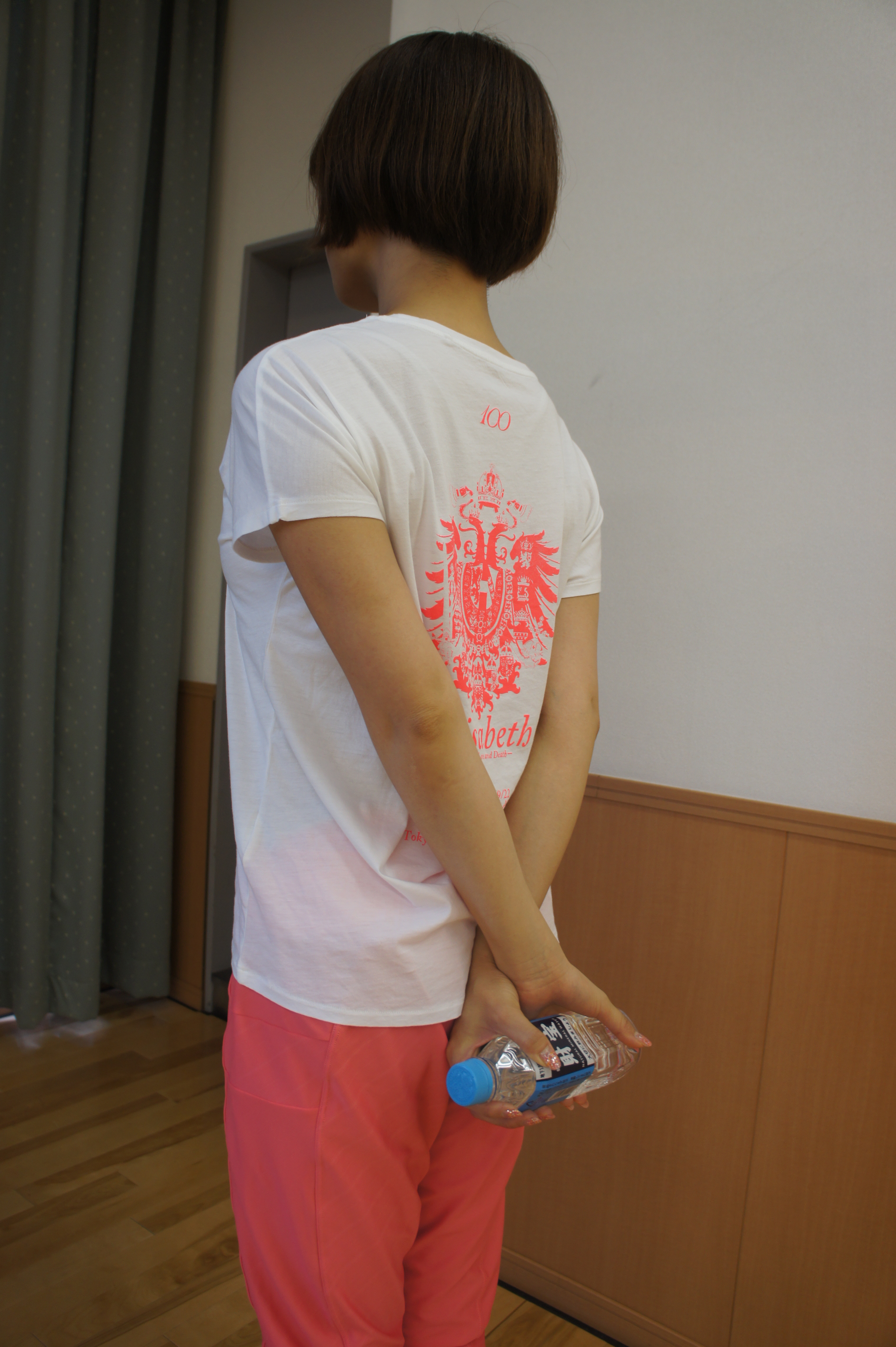 ペットボトルを後ろの手でクロスさせて持つ