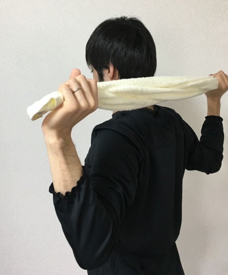 タオルをピンと張ったままひじを曲げて頭の後ろに腕を下ろす