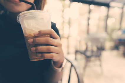 氷の入った飲み物を商品棚に置く
