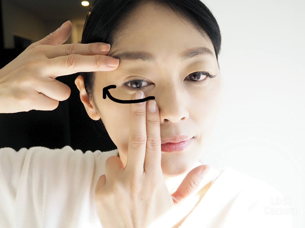 右手をキープしつつ、左手の中指で目の下をマッサージ