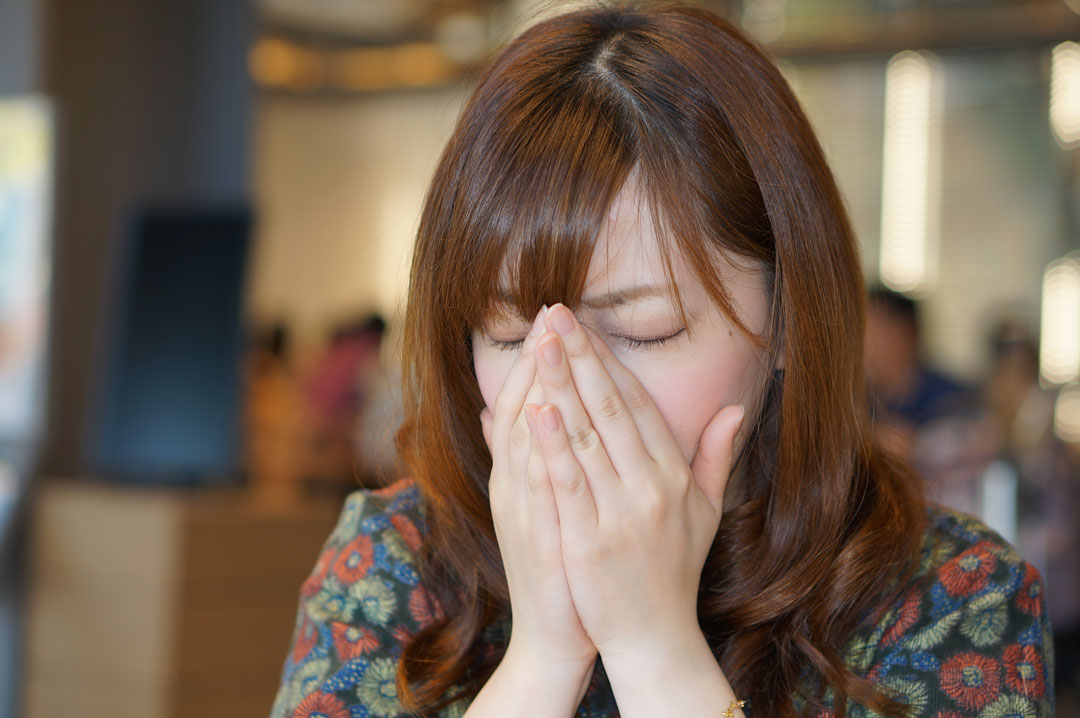 くしゃみを手でおさえる女性　クシャミ　咳　風邪　マスクなし