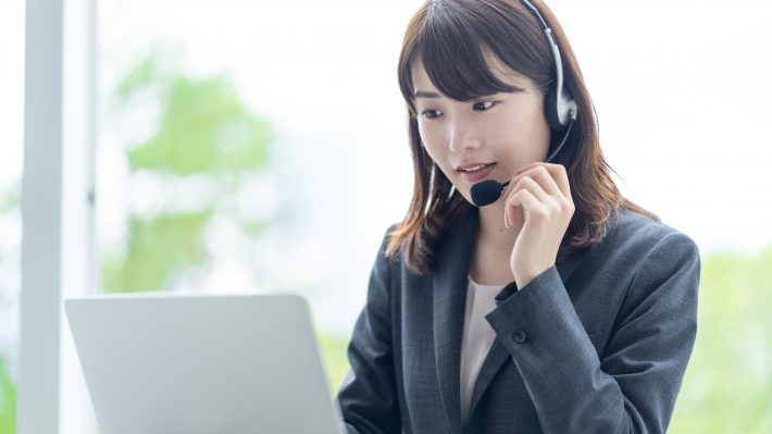 カスタマーセンターでクレーム対応に追われる女性