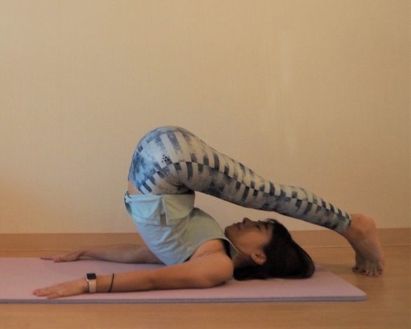 両足を持ち上げ、つま先を頭の先の床につける