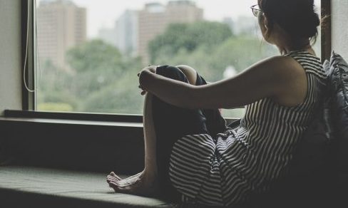 悩む女性　窓、曇、雨