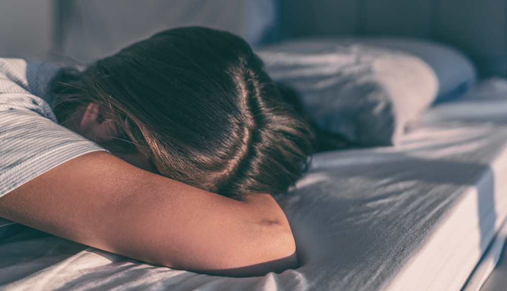 ベッドに突っ伏して泣く女性