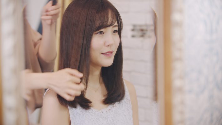 美容院でシースルーバングをオーダーする女性