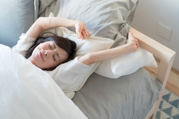 朝　ベッド　伸びる女性