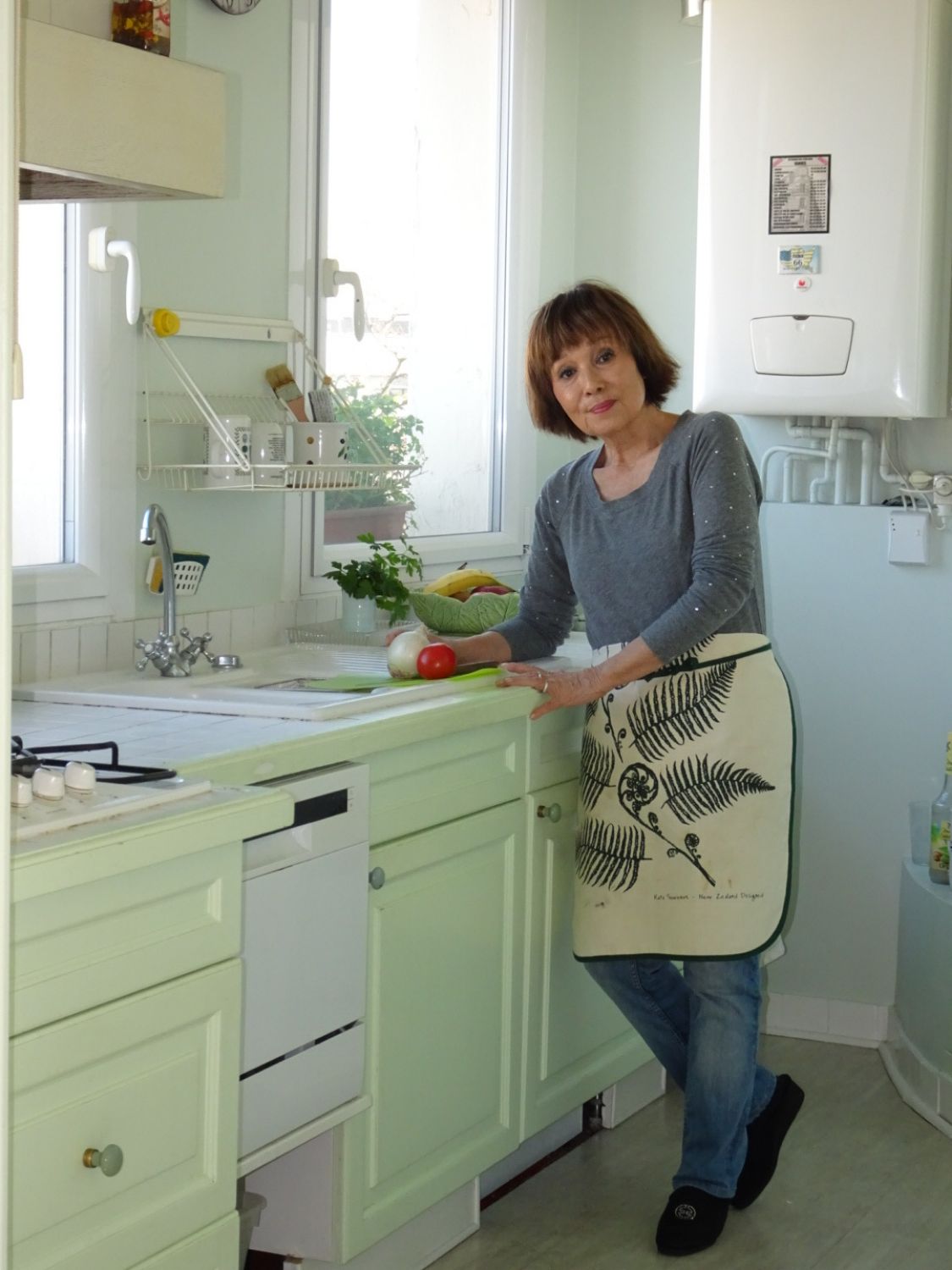 窓から外が見えるお気に入りの自宅キッチンで料理中