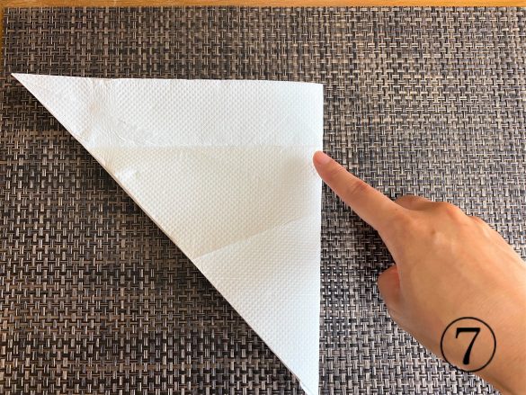 (7)もう一度逆三角形に開き、右端と左端の角が合うように半分に折る