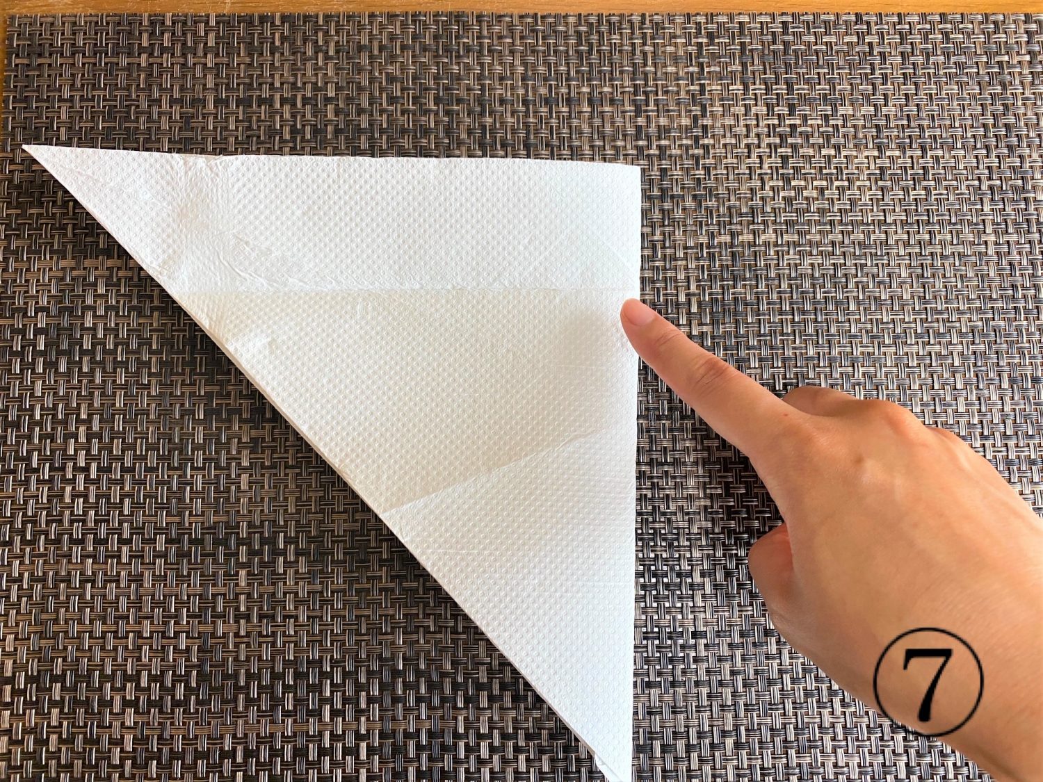 (7)もう一度逆三角形に開き、右端と左端の角が合うように半分に折る