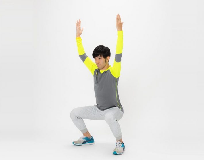 (3)お尻を軽く後ろへ引きながら腰を落とし、同時に腰の横にあった腕を頭の上に向かってあげていきます