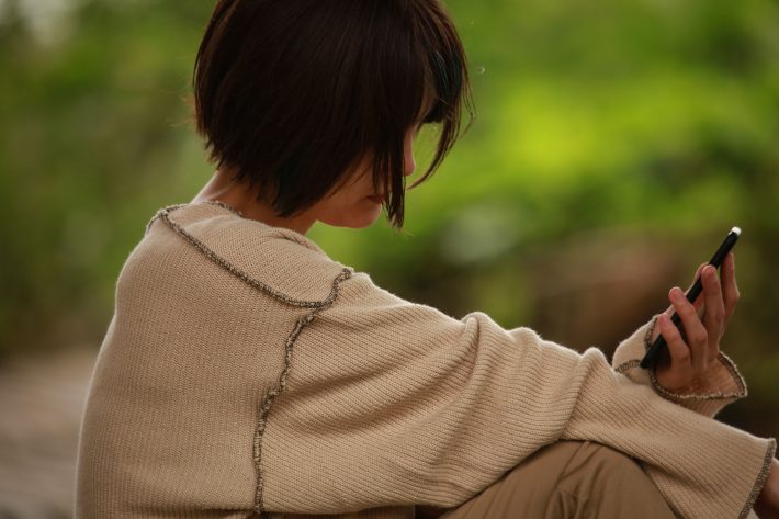 悩む　女性　スマホ