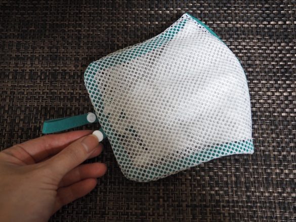 それを2つ折りにし、スナップボタンをとめて洗濯機へ