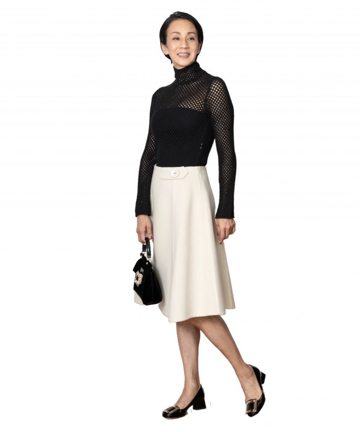 透け感のあるニットをインしてワンピース風に。モノトーンでまとめて小ぶりのバッグをきかせた大人のファミニン。