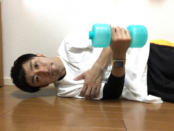 2. 右手でダンベルを持ち、右肘を曲げた状態にします