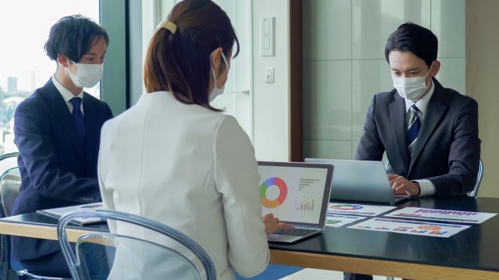 マスクをして打ち合わせをするビジネスマン