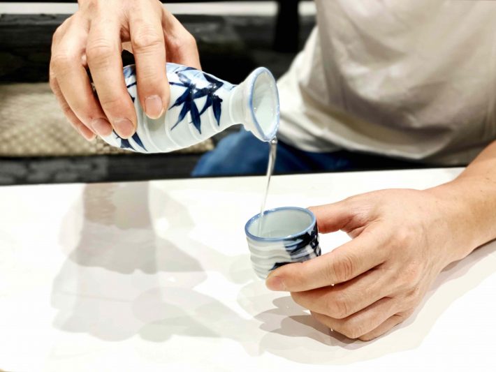 手酌酒をする男性の手元