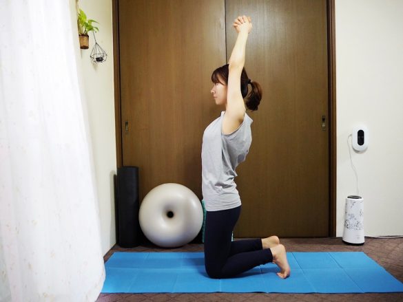 (1)床にひざ立ちになり、両腕を頭上に伸ばしたら指を組む。