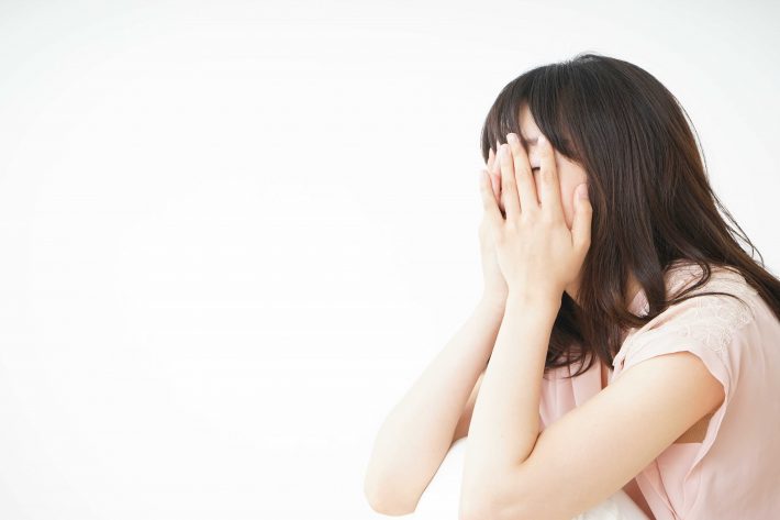 頭をかかえる女性