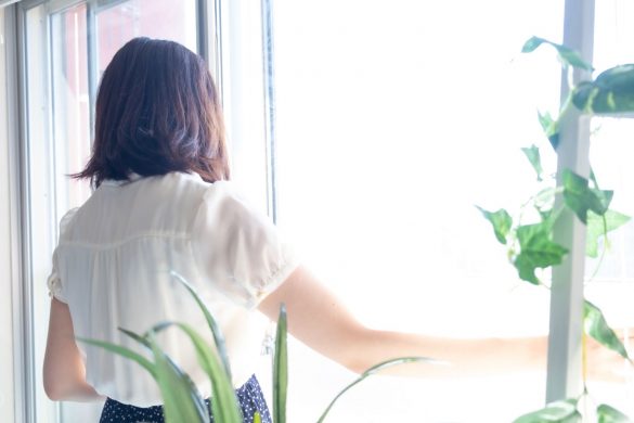 窓際に立つ女性の後ろ姿