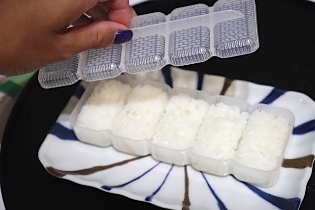 底を押してにぎり寿司を取り出す