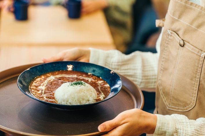 カレーライスを運ぶホールスタッフ