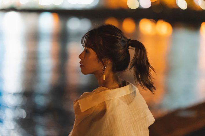 海岸で遠くを見つめる女性