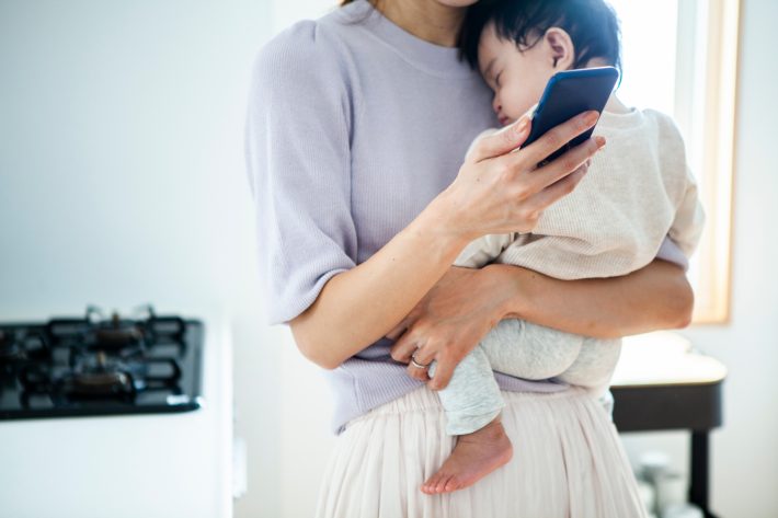 スマホを見る母親