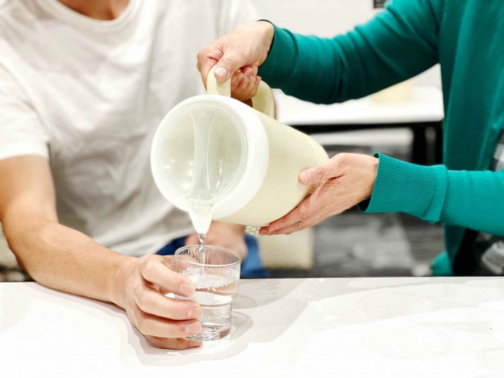 コップに水を入れる女性の手