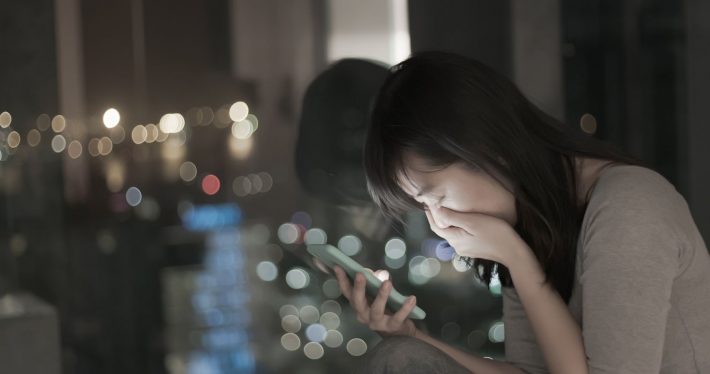 スマホを見て絶望する女性