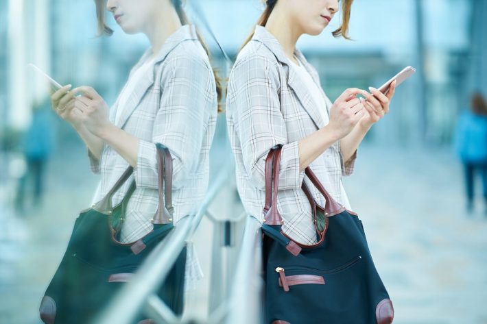スマホを見て困った表情をする女性