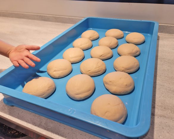 発酵したピザ生地（ハンドトス）。子どもの手のひらサイズの生地を薄くのばしていく