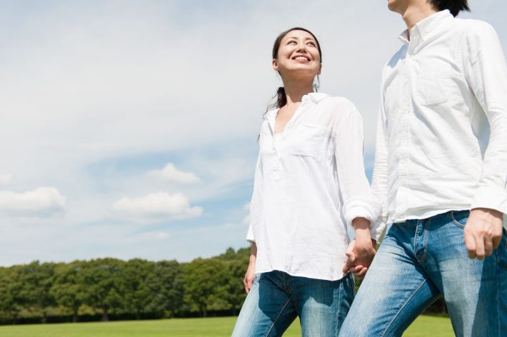 恋人と手をつないでいる女性