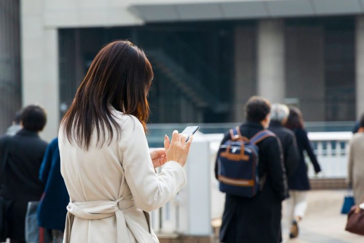 スマホを見ながら歩く女性