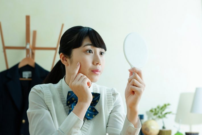 手鏡を持った女子学生