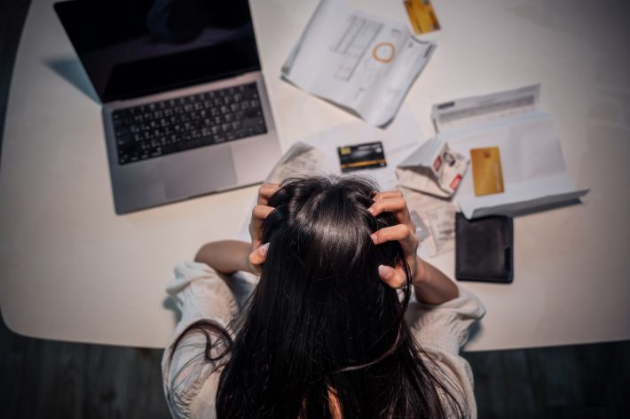 明細書を見て頭を抱える女性