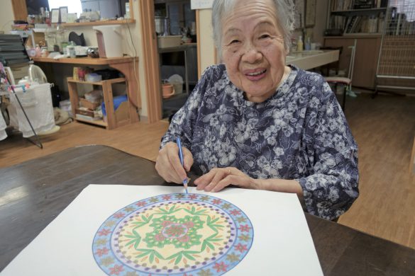 マンダラの図柄に色を塗る村上さん