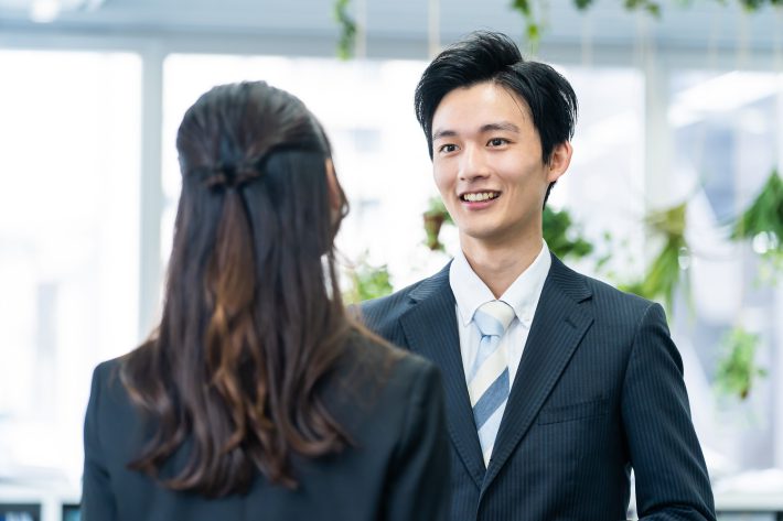 会社で話をする男女