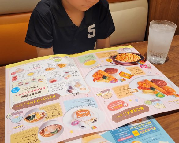 デニーズでメニューを見る筆者の息子
