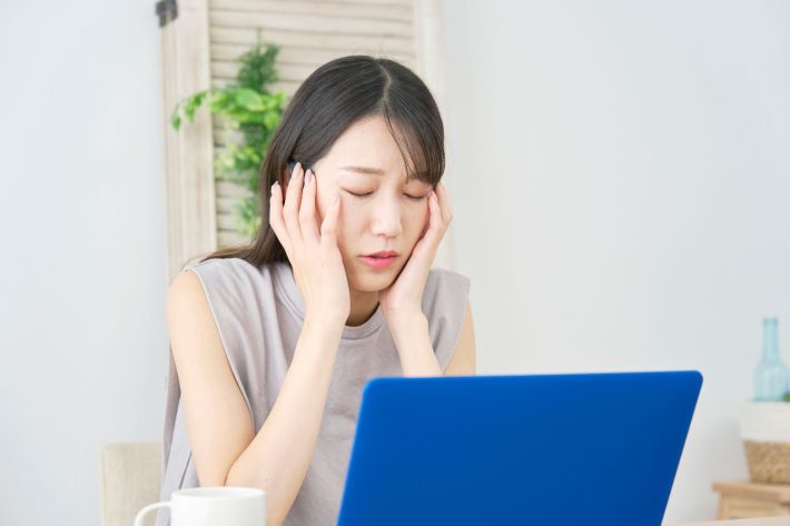 PC前で悩む女性