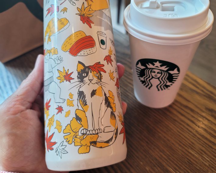 春バージョン、夏バージョンでもおなじみの三毛猫は、紅葉に包まれたほっこりスタイル