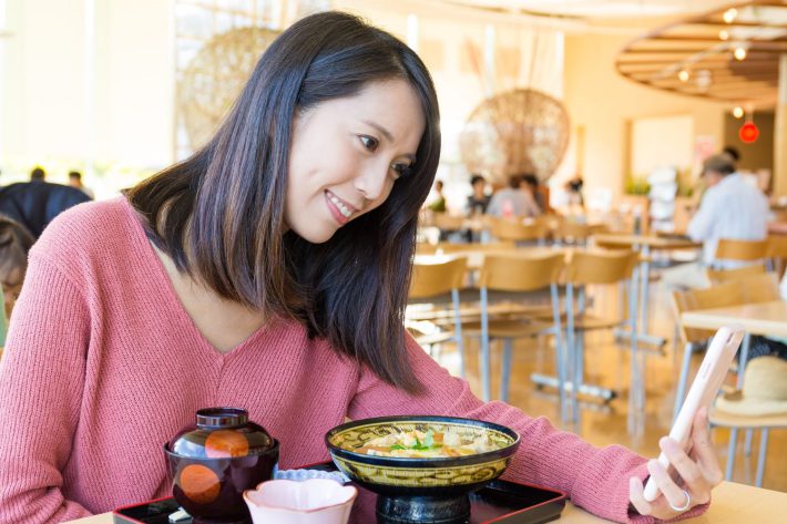 ビデオ通話しながら食事する女性