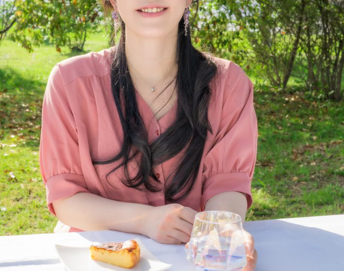 屋外でケーキを食べる女性