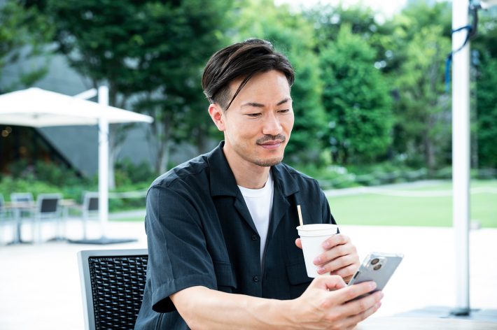 カフェでスマホを見る男性