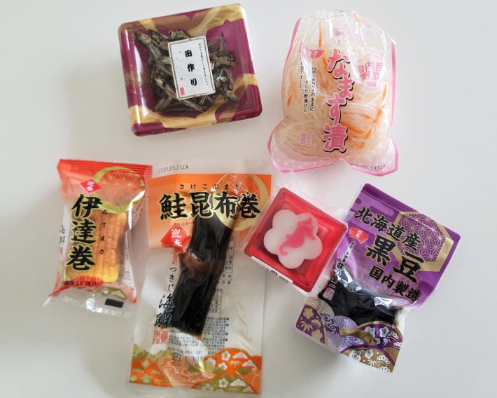 （左上から時計回りに）田作り162円、なます漬108円、北海道産黒豆108円、白梅ようかん108円、鮭昆布巻108円、伊達巻162円