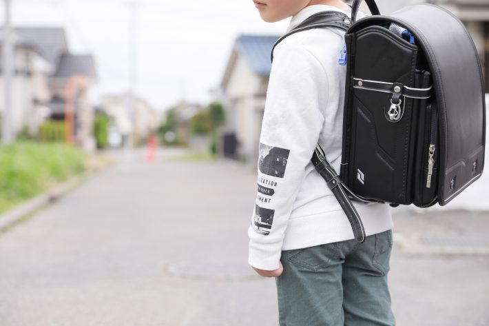 登下校中のランドセルを背負った小学生の少年