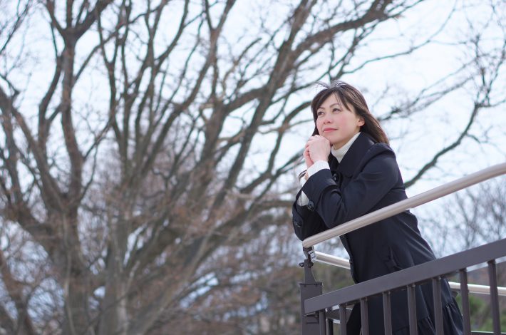 フェンス際に立つ女性