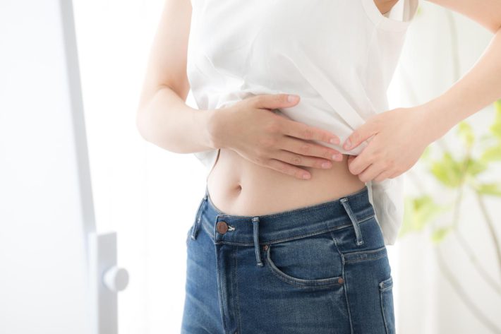 ウェストやお腹周りをさわる女性