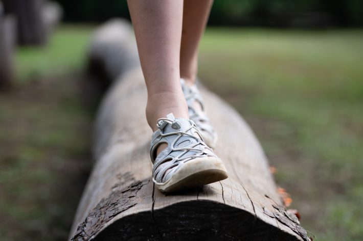 丸太の上を歩く子供の足